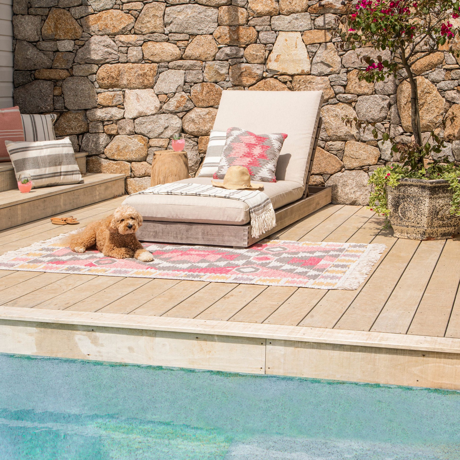 Pet-friendly washable outdoor rug in pink diamond pattern on timber pool deck
