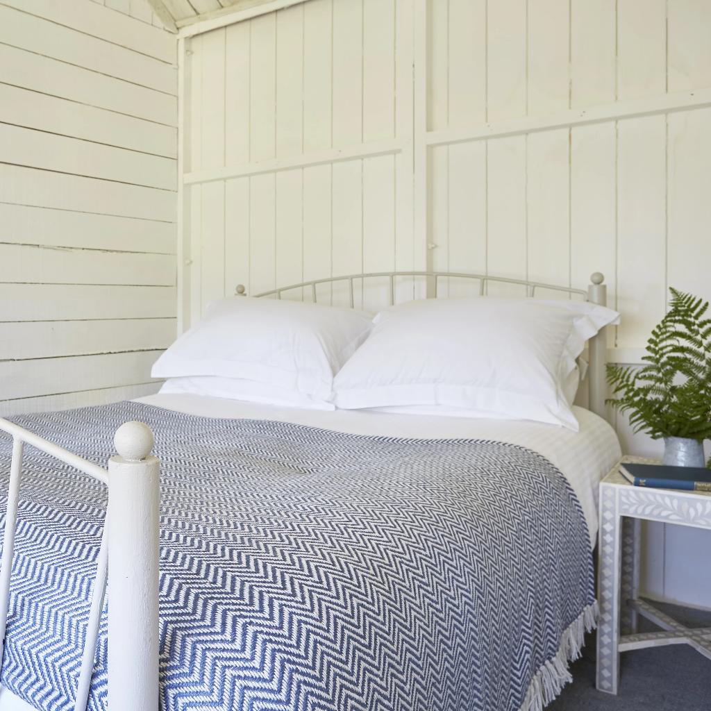 Navy Herringbone Blanket on a bed